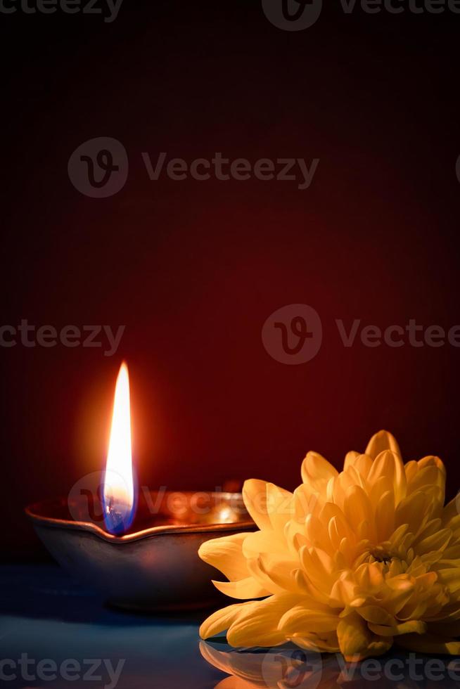 Happy Diwali. Traditional symbols of Indian festival of light. Burning diya oil lamps and flowers on red background. photo