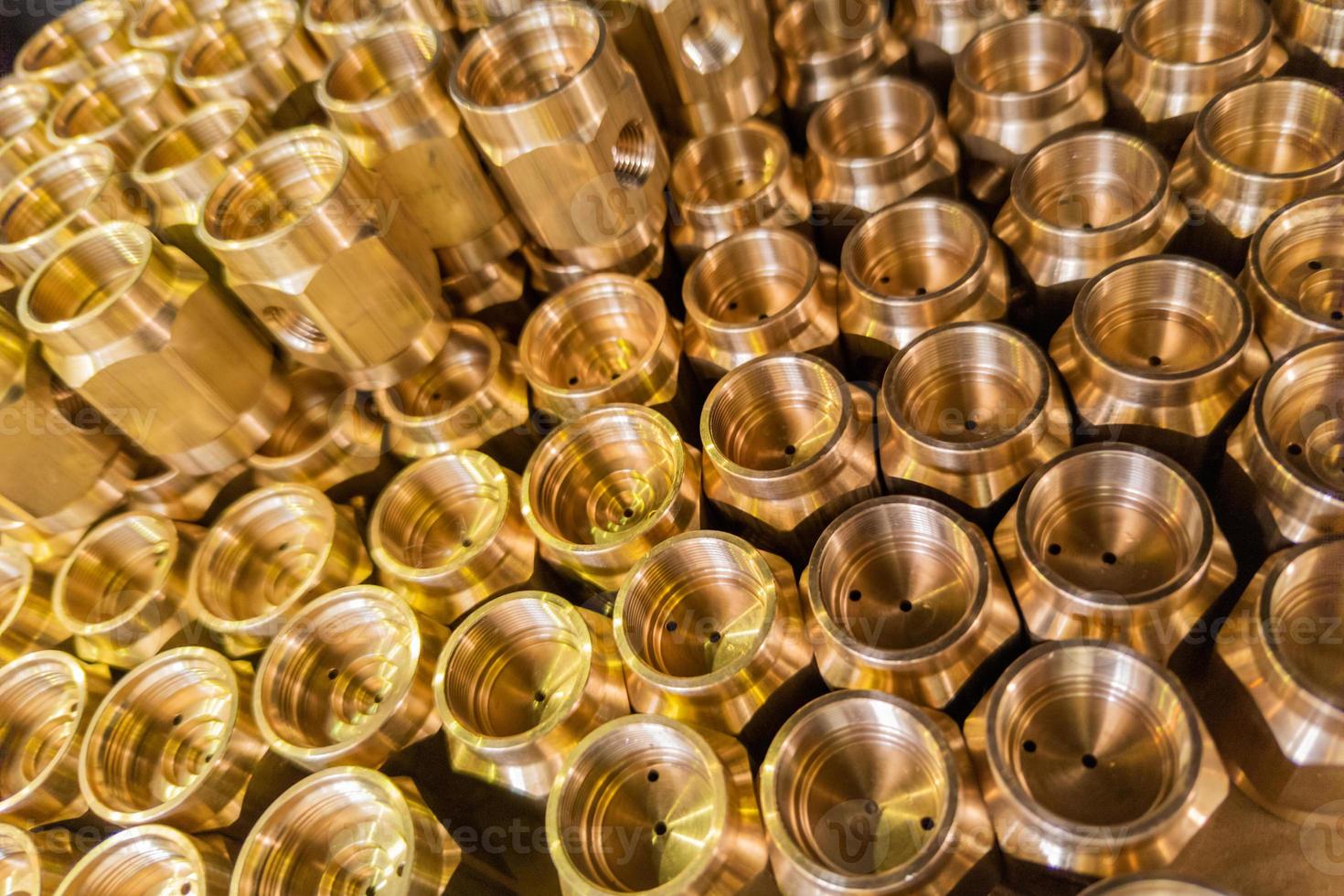 abstract industrial background of shiny brass metal threaded hexagonal parts photo
