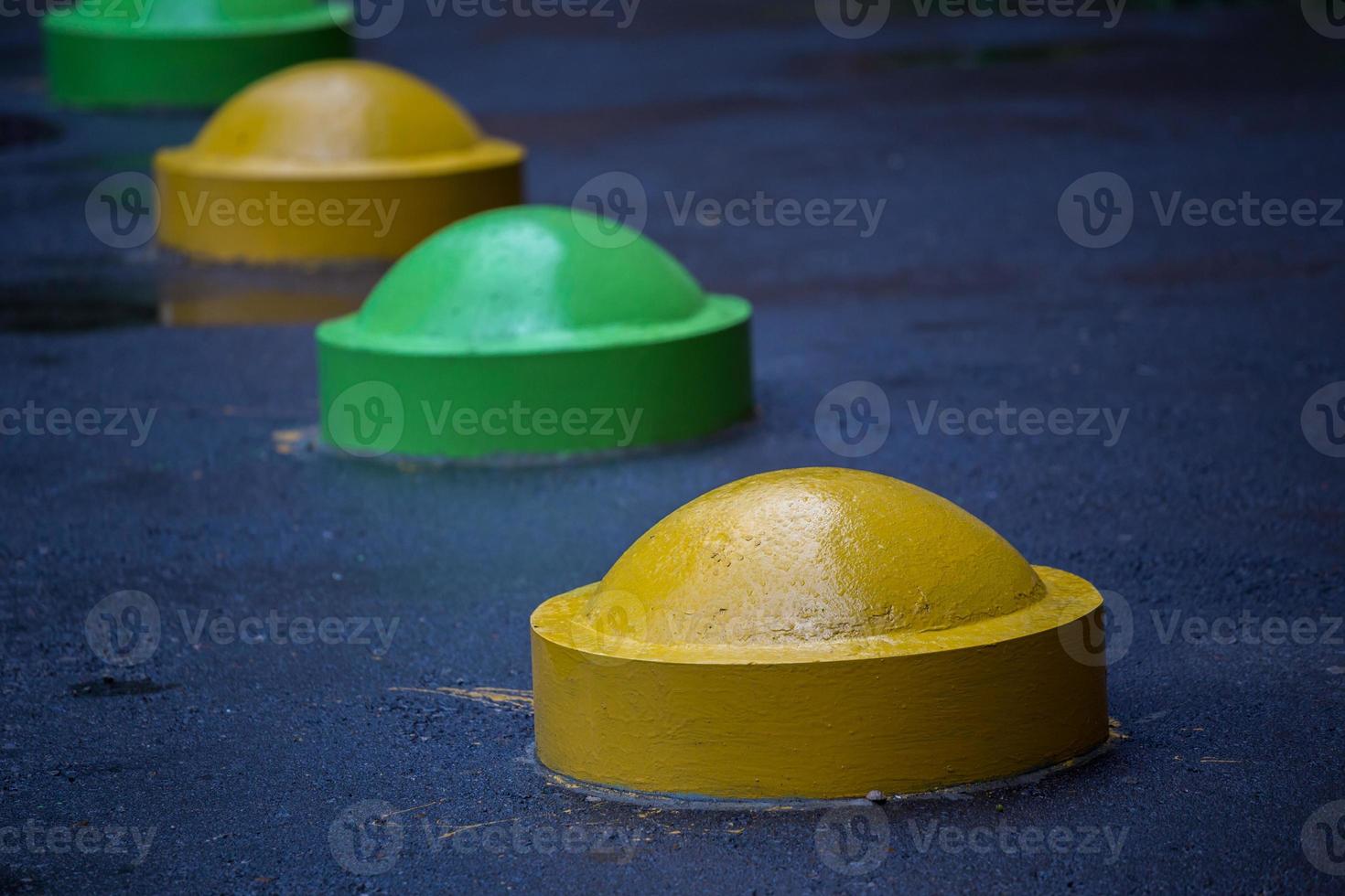 colorful road parking prevention hemisphere bollards close-up with selective focus and blur photo