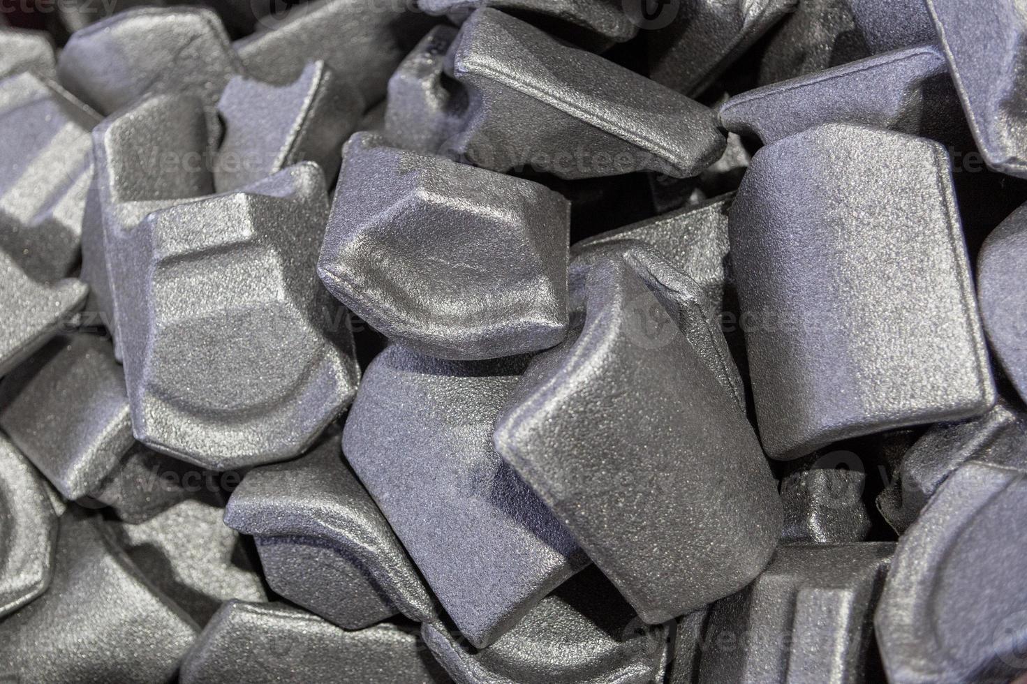 heap of gray steel forgings after shot blasting - close-up natural heavy industrial pattern with selective focus photo