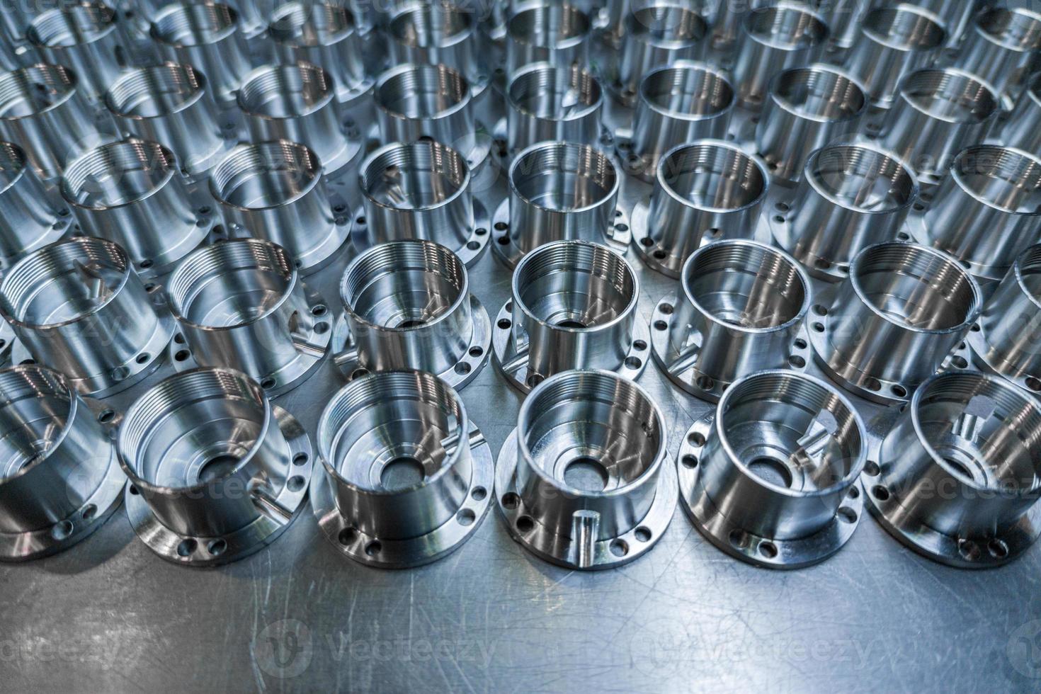 a batch of shiny metal cnc aerospace parts production - close-up with selective focus for industrial background photo