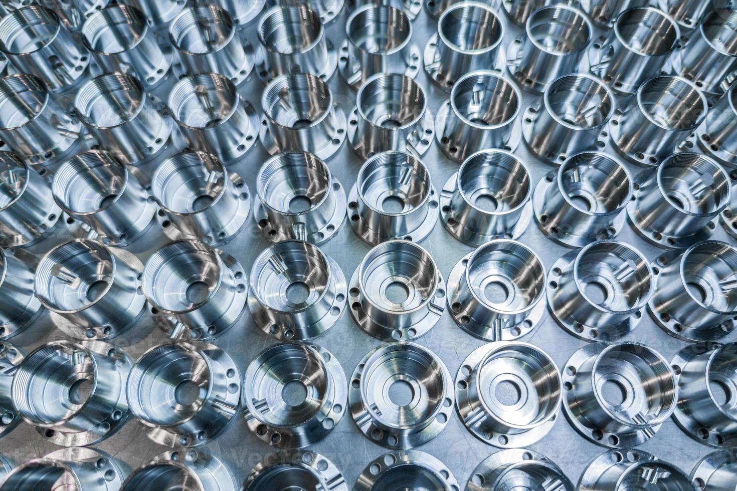 a batch of shiny metal cnc aerospace parts production - close-up with selective focus for industrial background photo