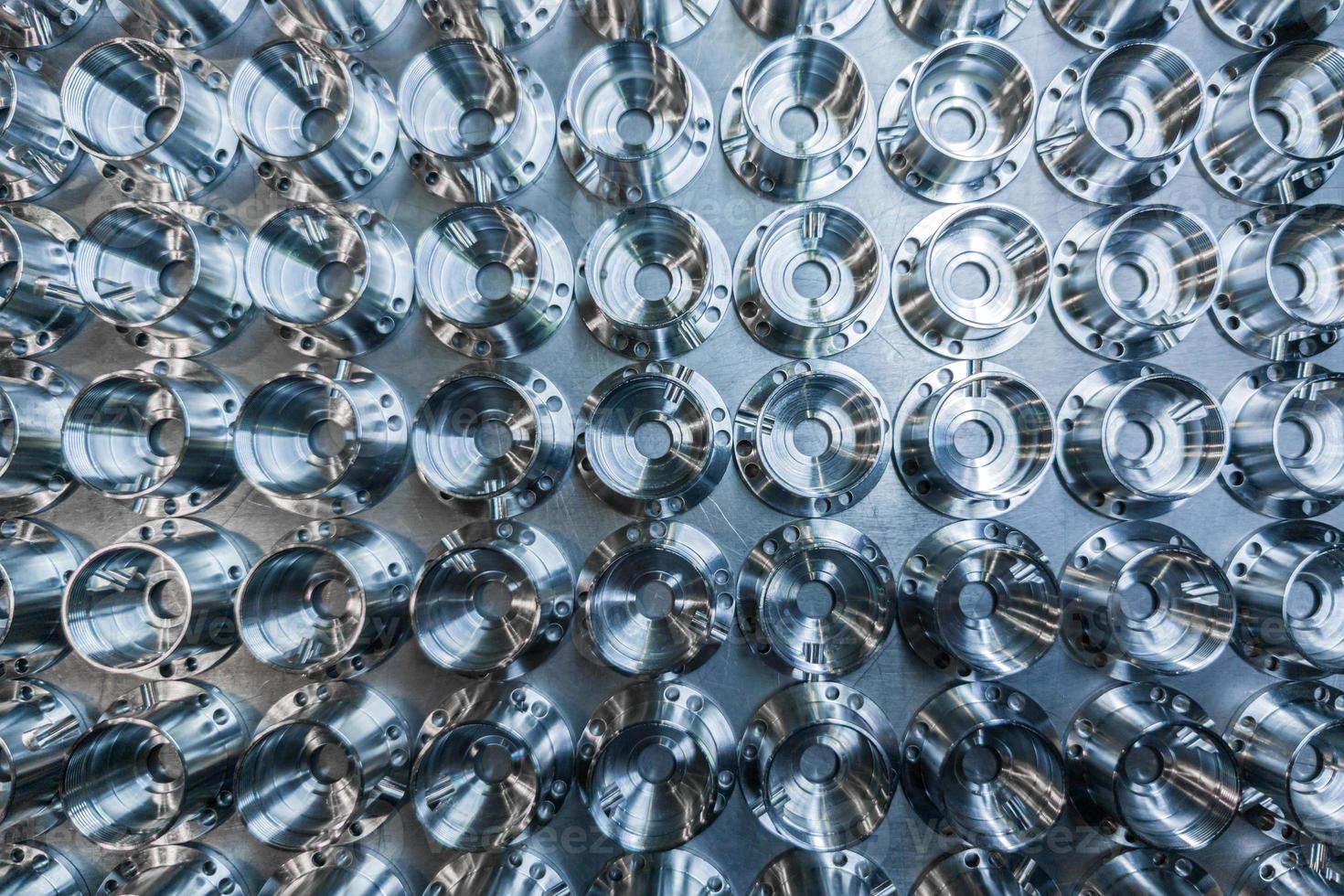 a batch of shiny metal cnc aerospace parts production - close-up flat lay with selective focus for industrial background photo
