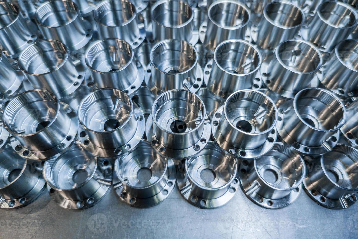 a batch of shiny aluminium aerospace parts made with cnc machine - close-up with background blur, industrial backdrop photo