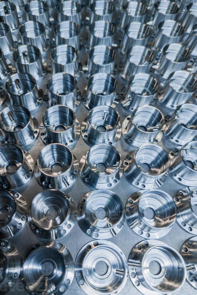 a batch of shiny metal cnc aerospace parts production - close-up in selective focus for industrial full frame background photo