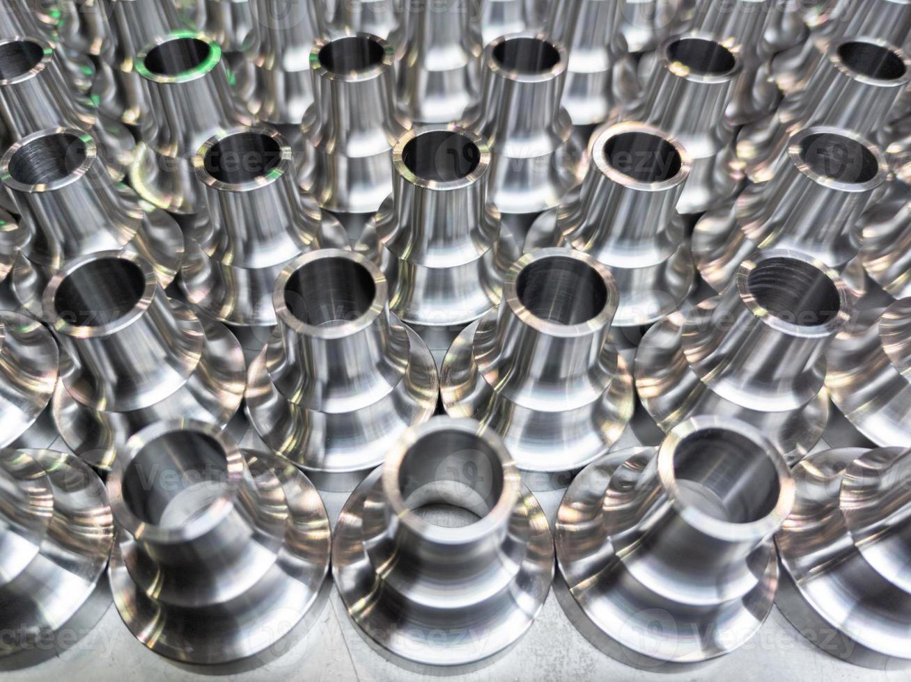 a batch of shiny steel cnc aerospace parts production - close-up with selective focus for industrial background photo