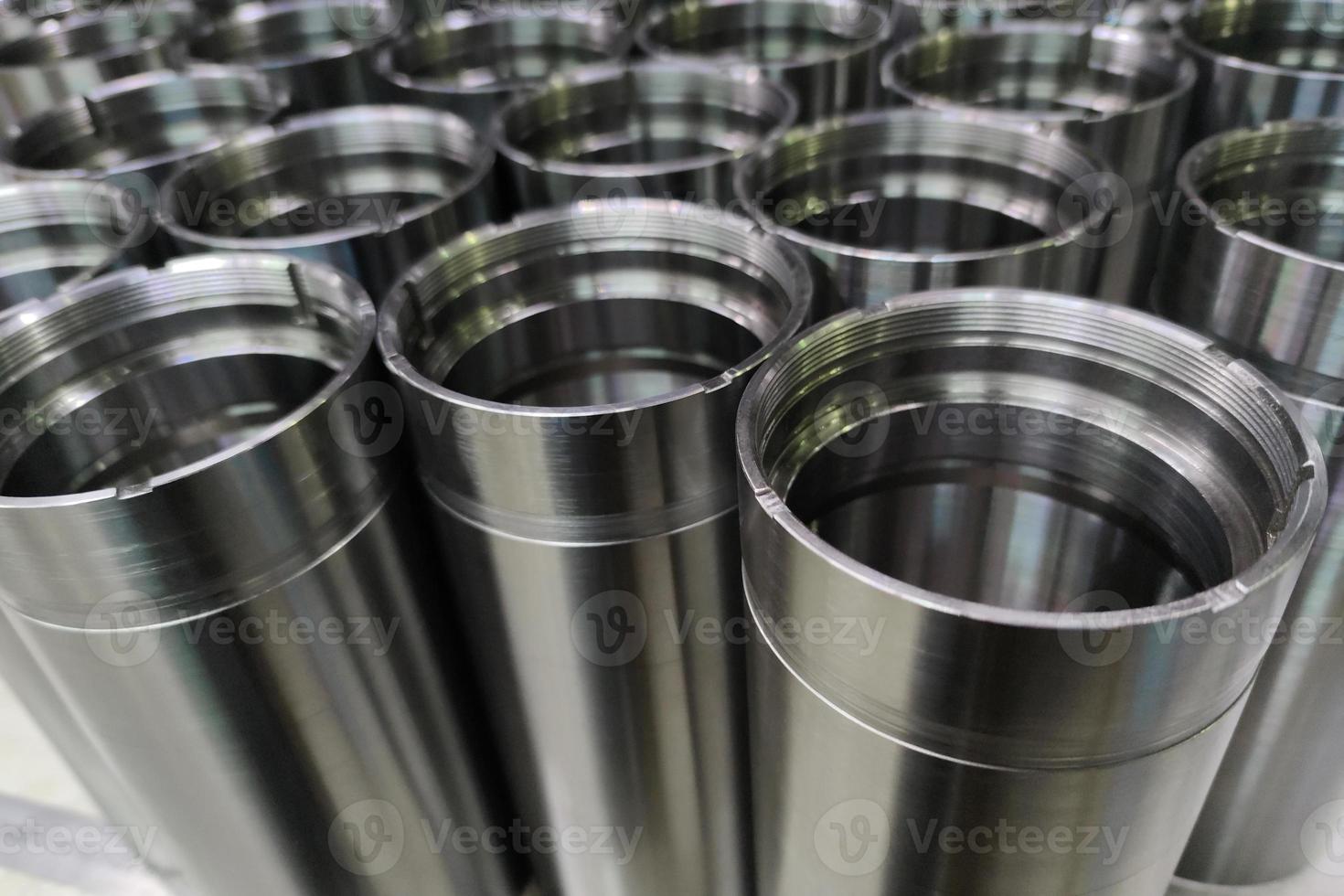 a close-up shot of shiny steel aerospace cnc turned tubes in a batch with selective focus and background blur photo