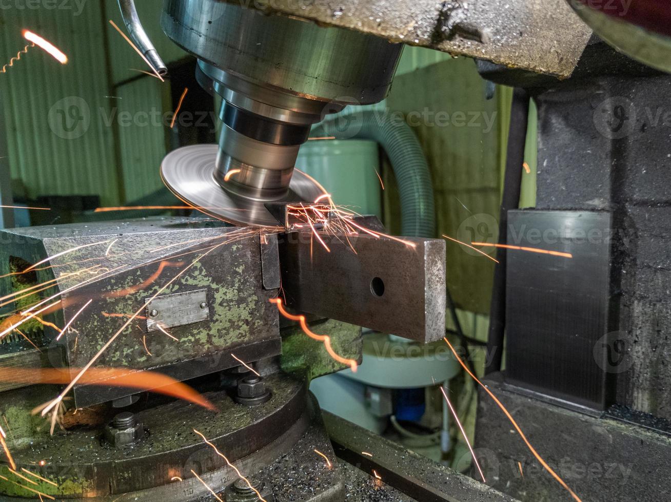 sloped disk industrial milling process with sparks - close-up with selective focus and blur photo