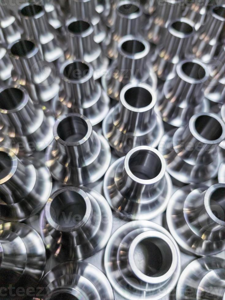 a batch of shiny steel cnc aerospace parts production - close-up with selective focus for industrial background photo