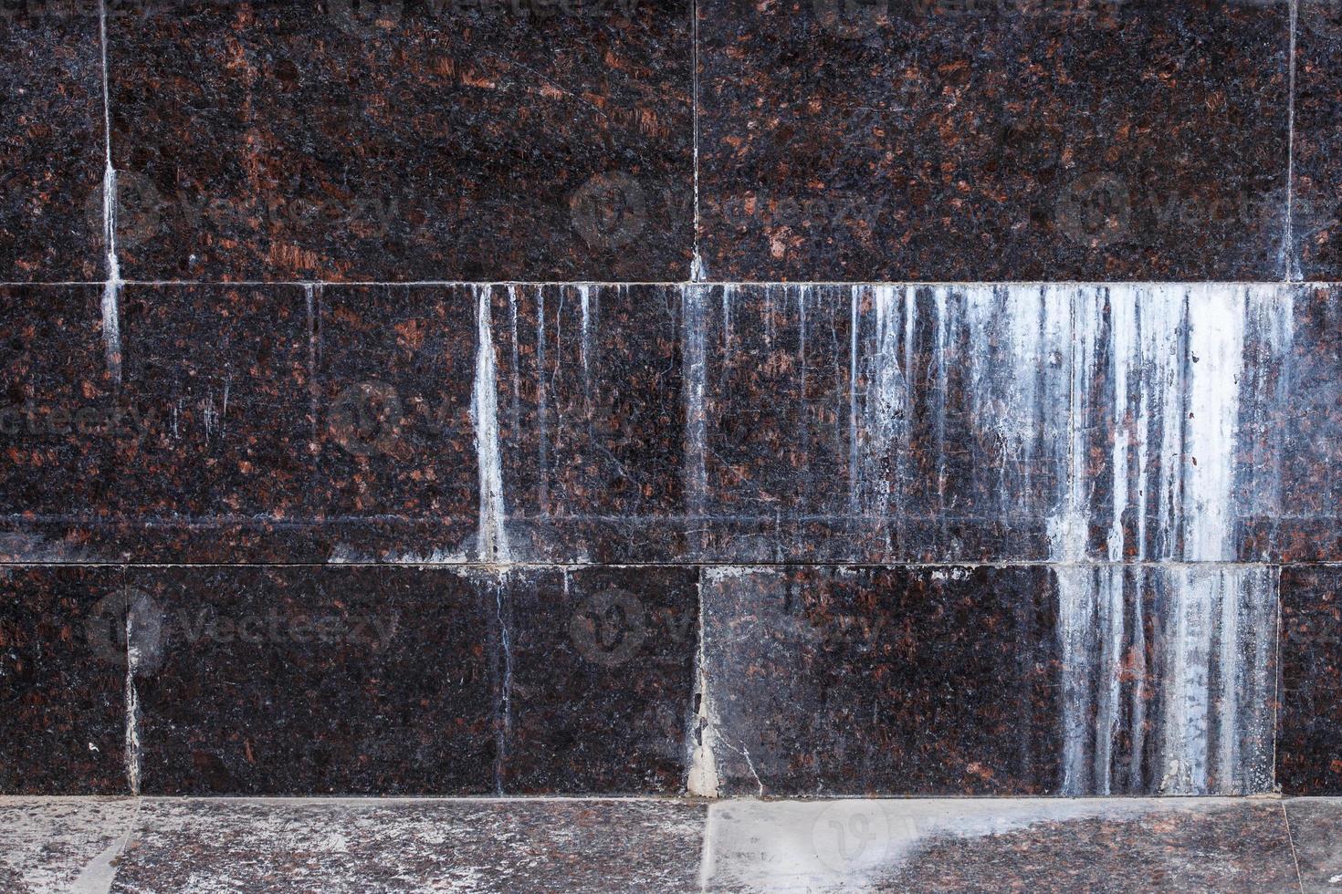 flat wall with rectangular natural tan brown granite tiles with white mineral drips photo