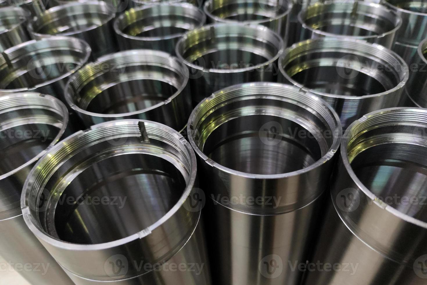 a close-up shot of shiny steel aerospace cnc turned tubes in a batch with selective focus and background blur photo