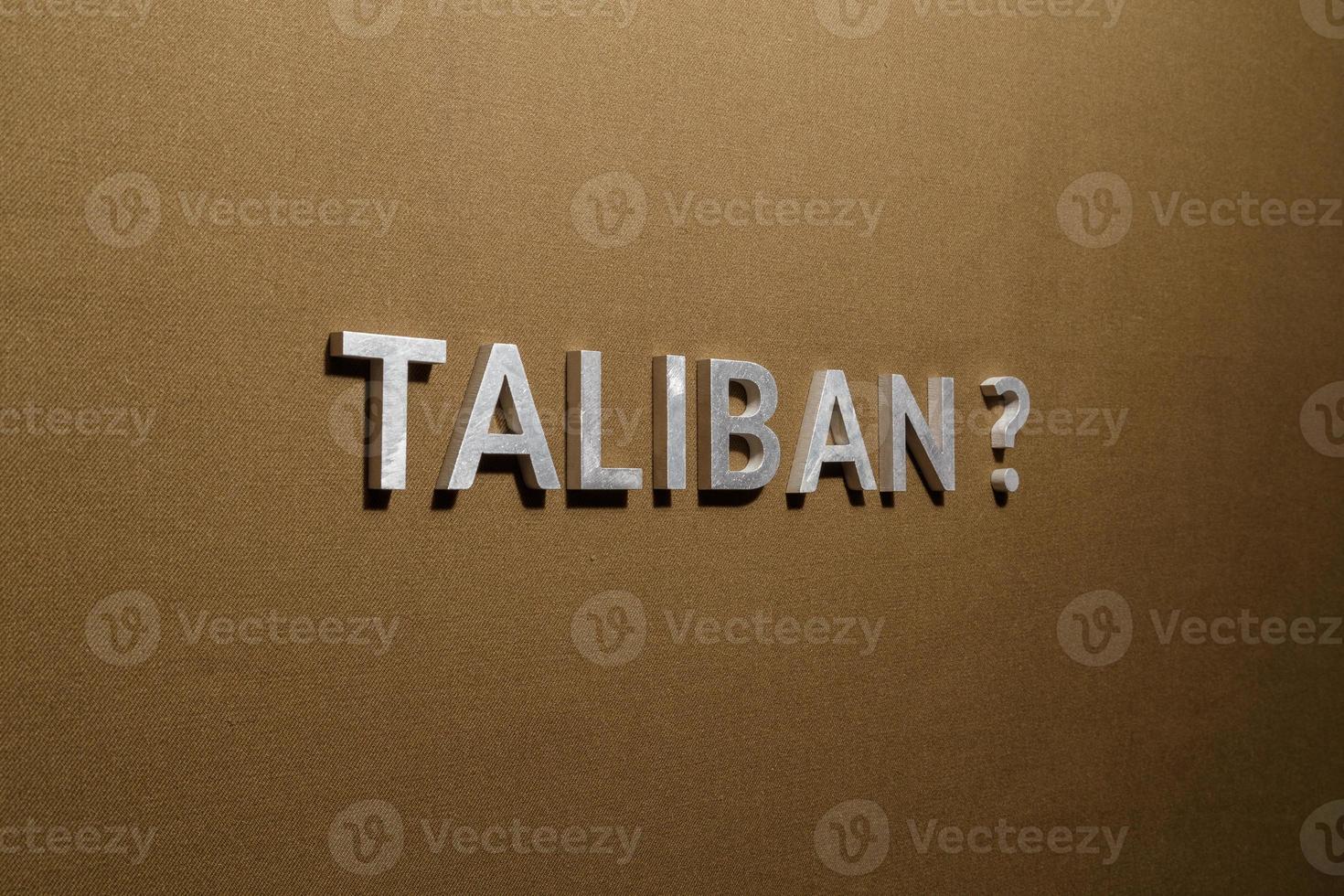 the question taliban laid with silver metal letters on rough tan khaki canvas fabric photo