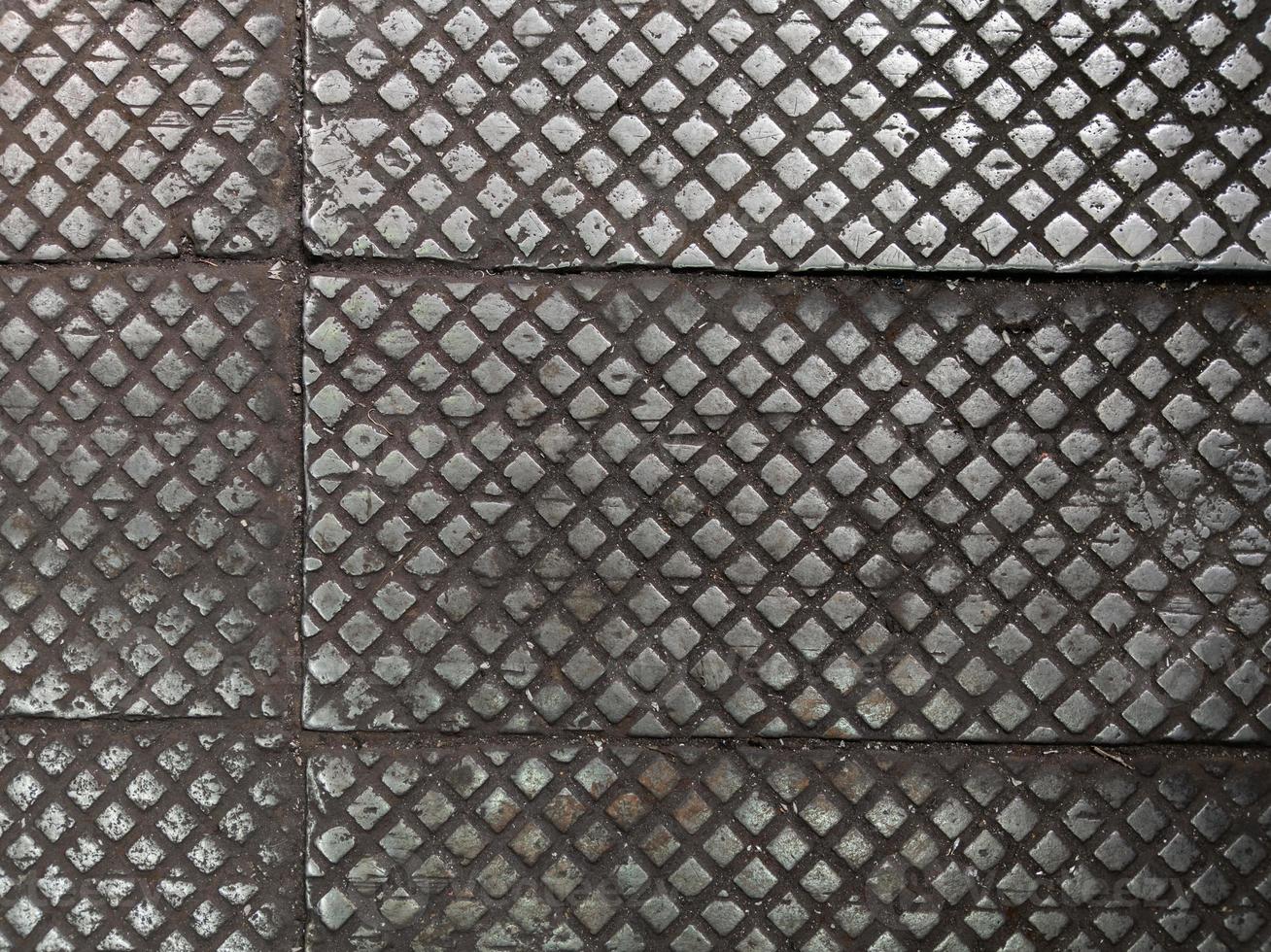 old cast iron factory floor tiles with checkered skid-proof pattern photo
