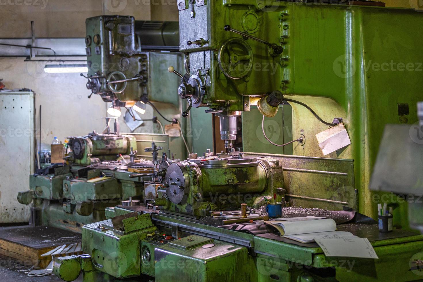 Two old and big soviet vertical 5-axis industrial milling and boring machines indoors with selective focus and blur. photo