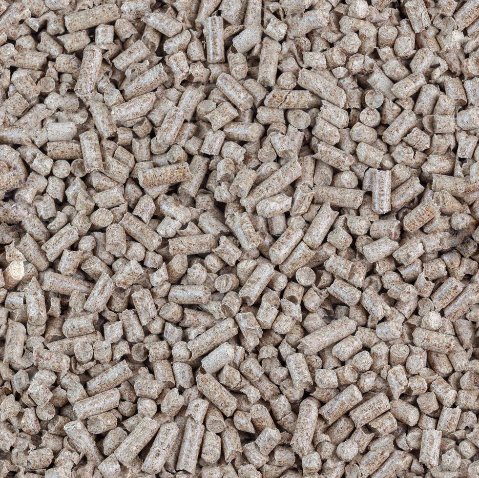pellets de aserrín de madera comprimida textura y fondo planos sin fisuras. biocombustible y arena para mascotas, mantillo. foto