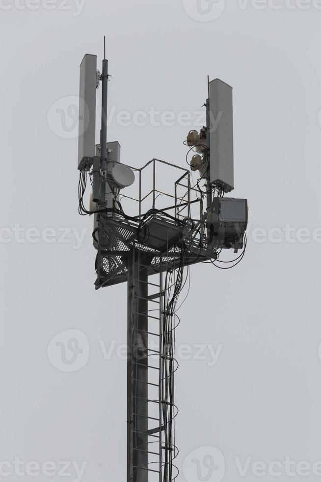 communication and gsm, wcdma, hspda and other 3g, 4g standarts tower close-up in cloudy weather photo