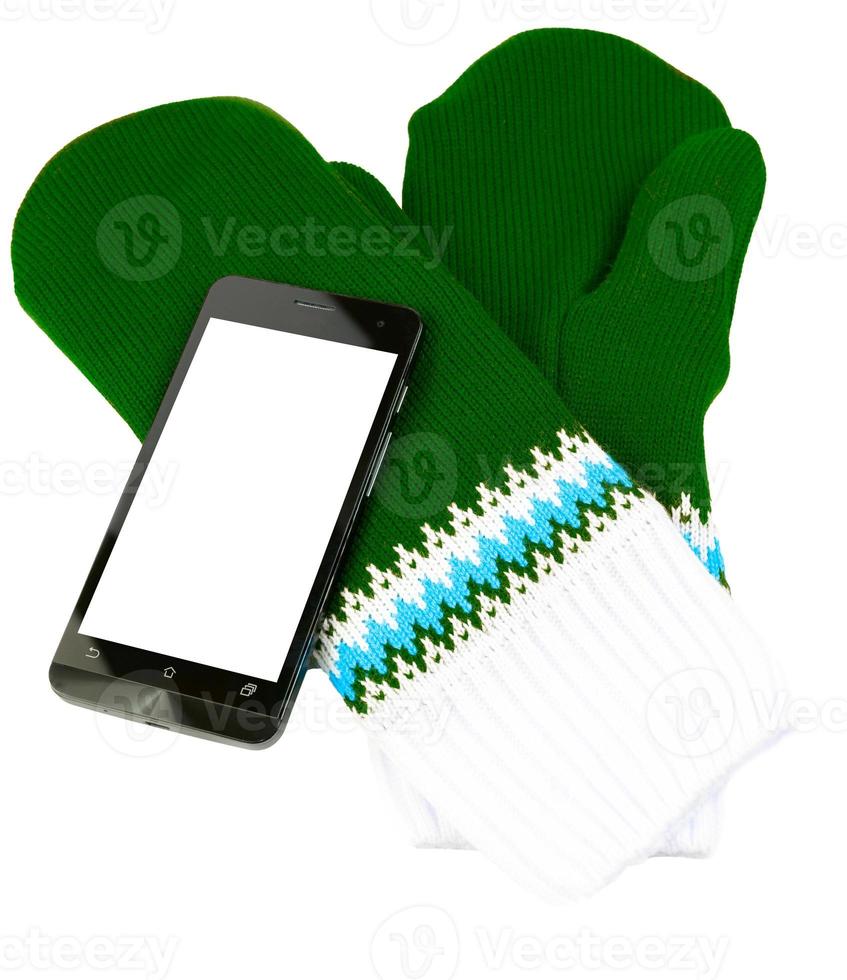 green and white knited mittens with cellphone isolated on white background photo