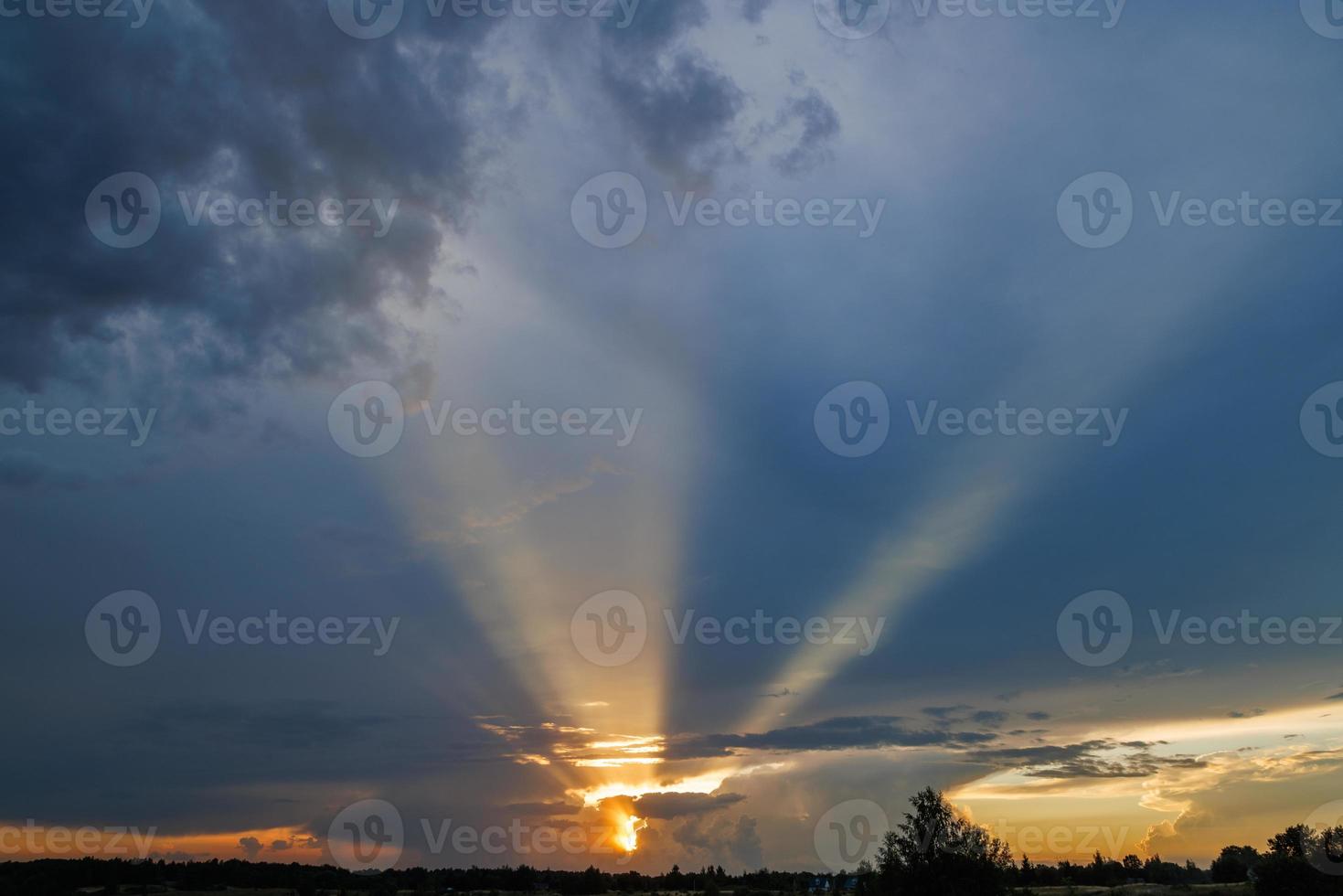 cloudy sunset sky with yellow sun rays without horizon photo