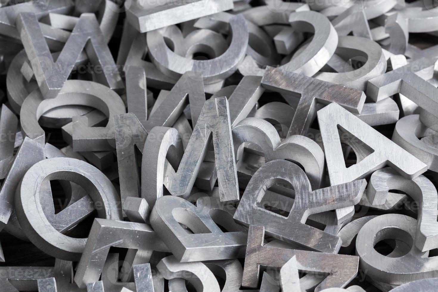 montón de caracteres alfabéticos de metal plateado cortados por máquina de chorro de agua foto
