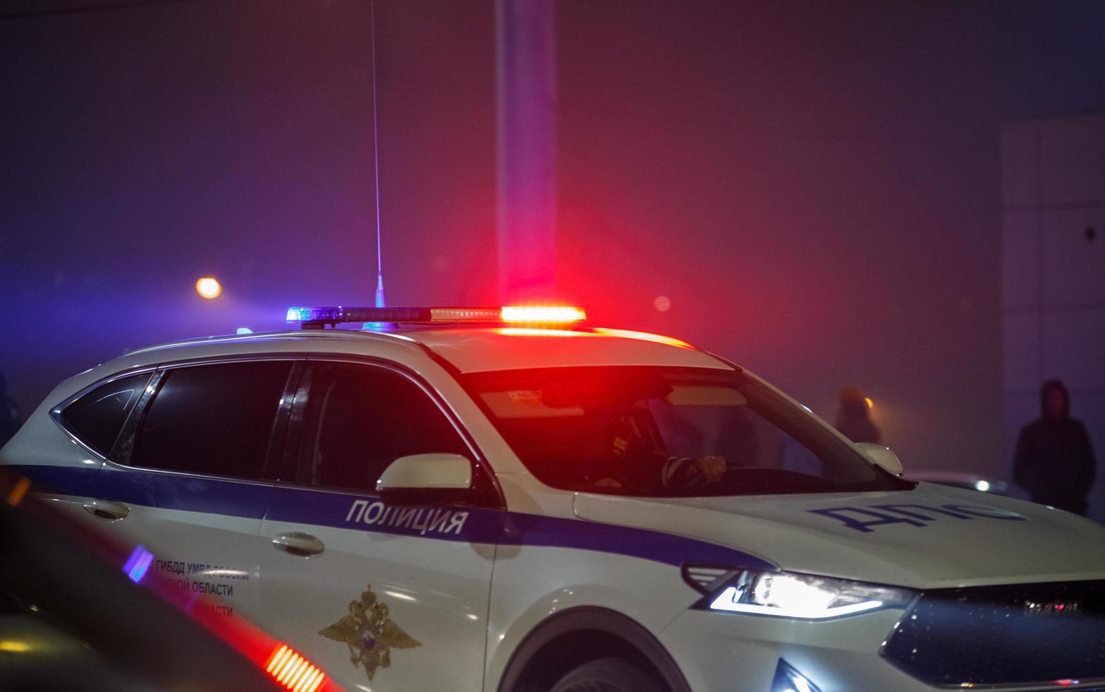 tula, rusia 9 de mayo de 2021 coche de policía de carretera con luz de sirena roja y azul encendida en su techo en la carretera nocturna de la ciudad foto