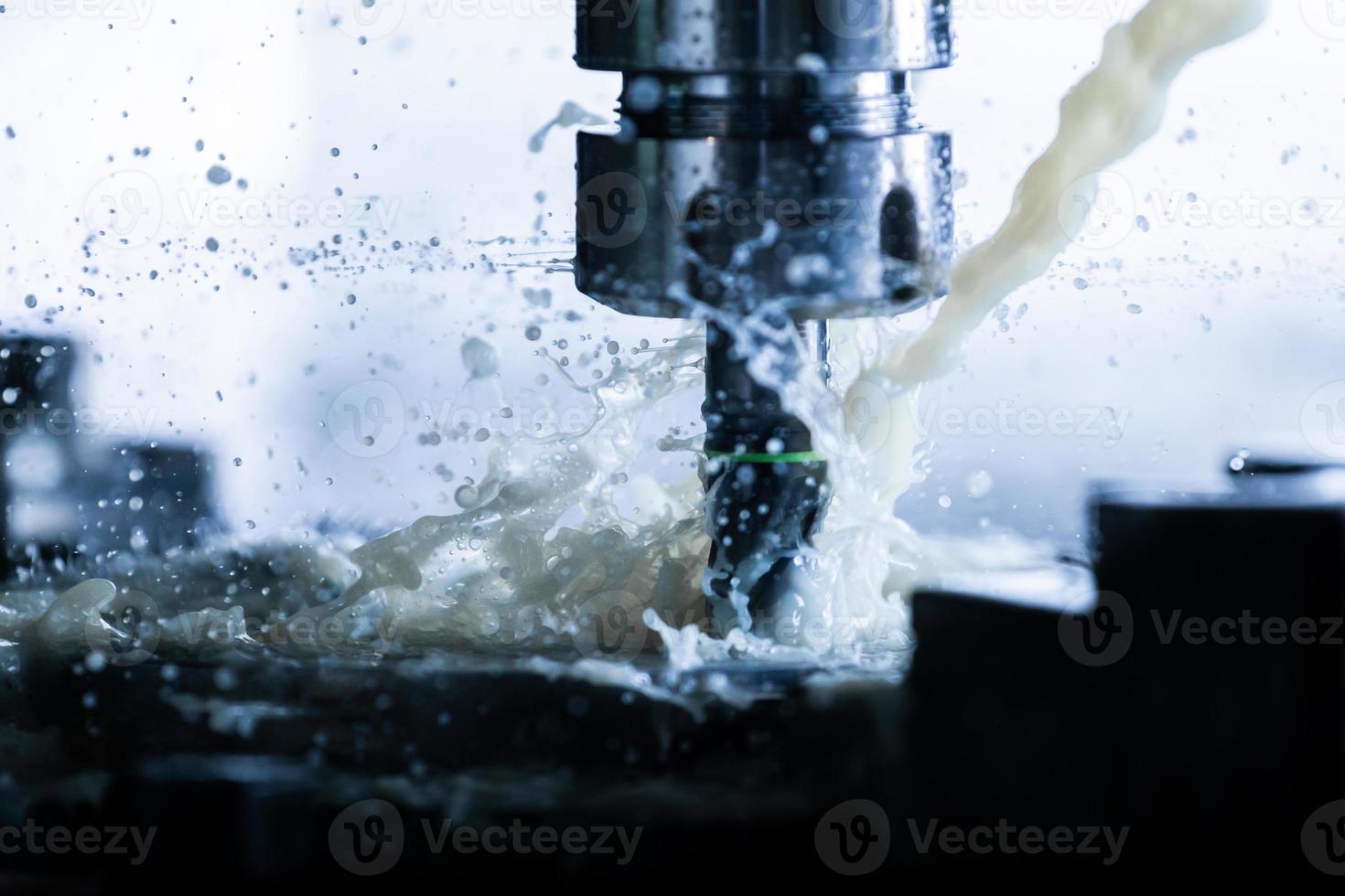 a process of vertical cnc steel milling with external water coolant streams, splashes and a lot of metal chips, high contrast photo