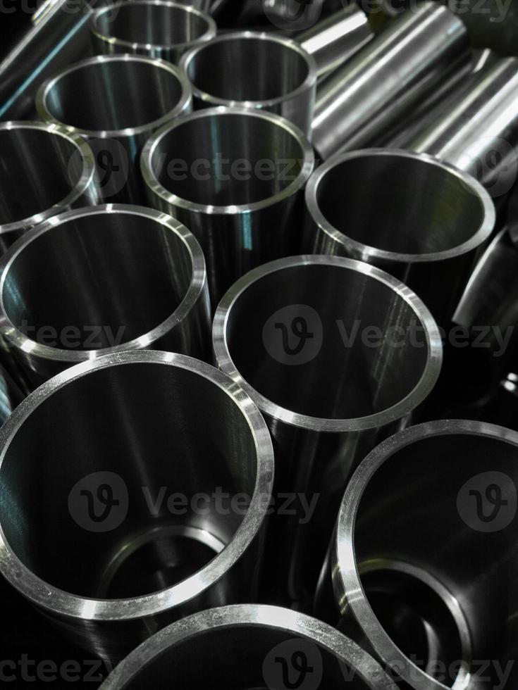fondo industrial oscuro con tubos de acero brillante mecanizado cnc - enfoque selectivo y tecnología de desenfoque de lente foto