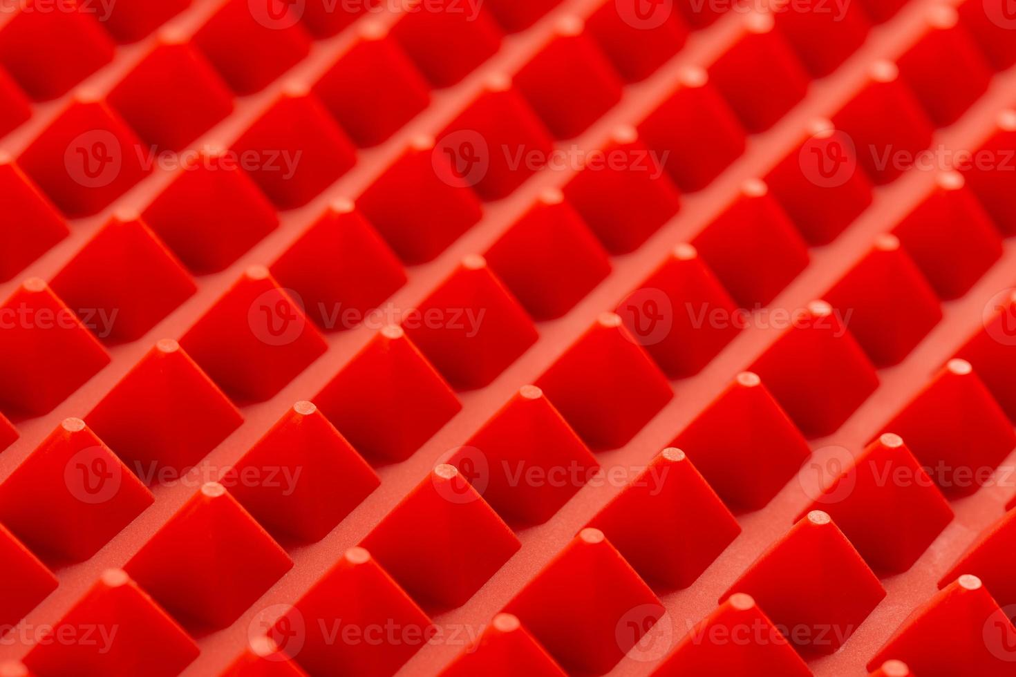 abstract red silicone pyramids array close-up background photo