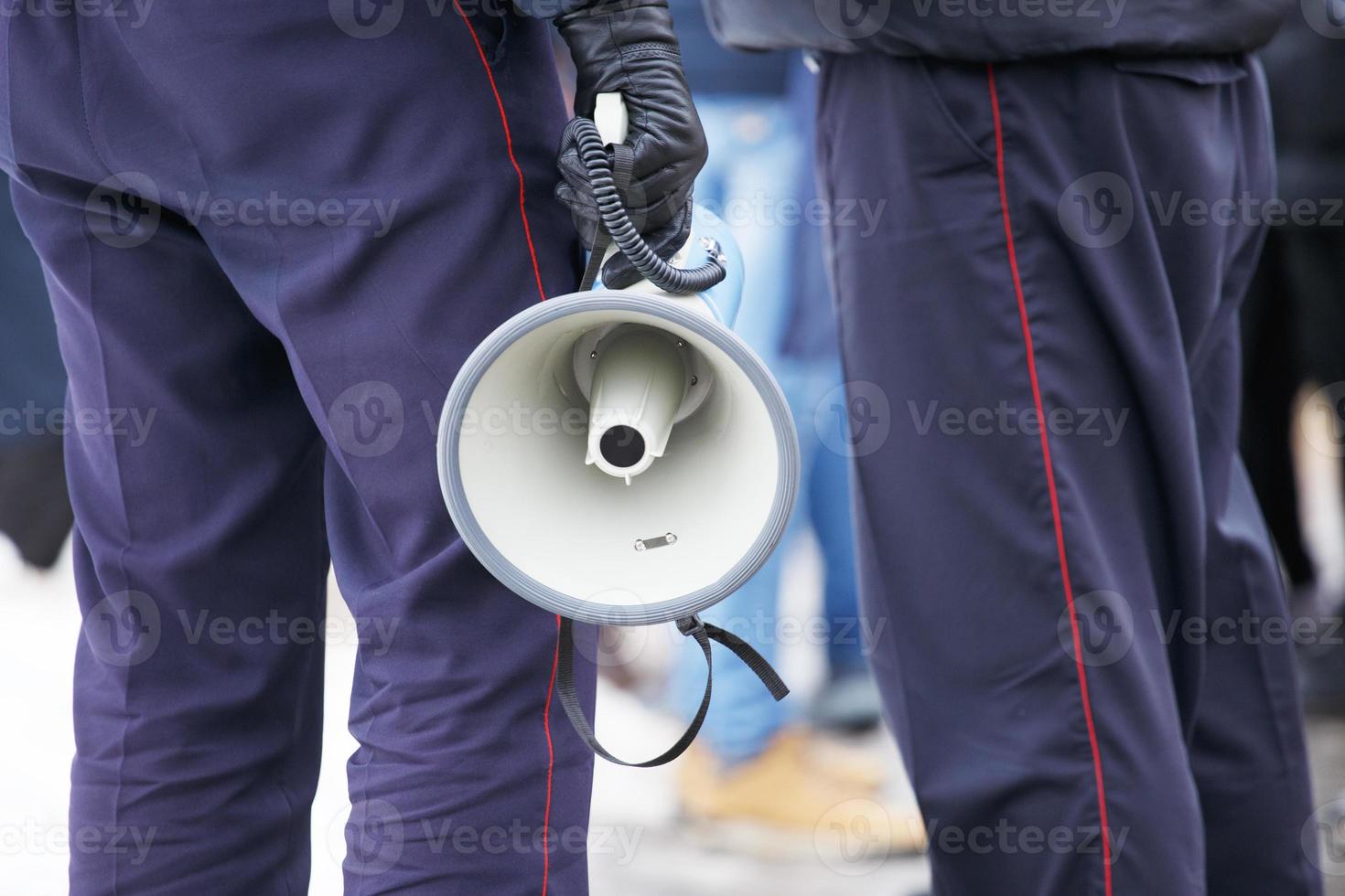 police officer holding loudspeaker megaphone outdoors, close-up photo