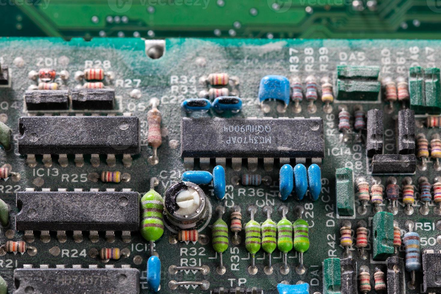 dark background of old electronic circuit board closeup with dus photo