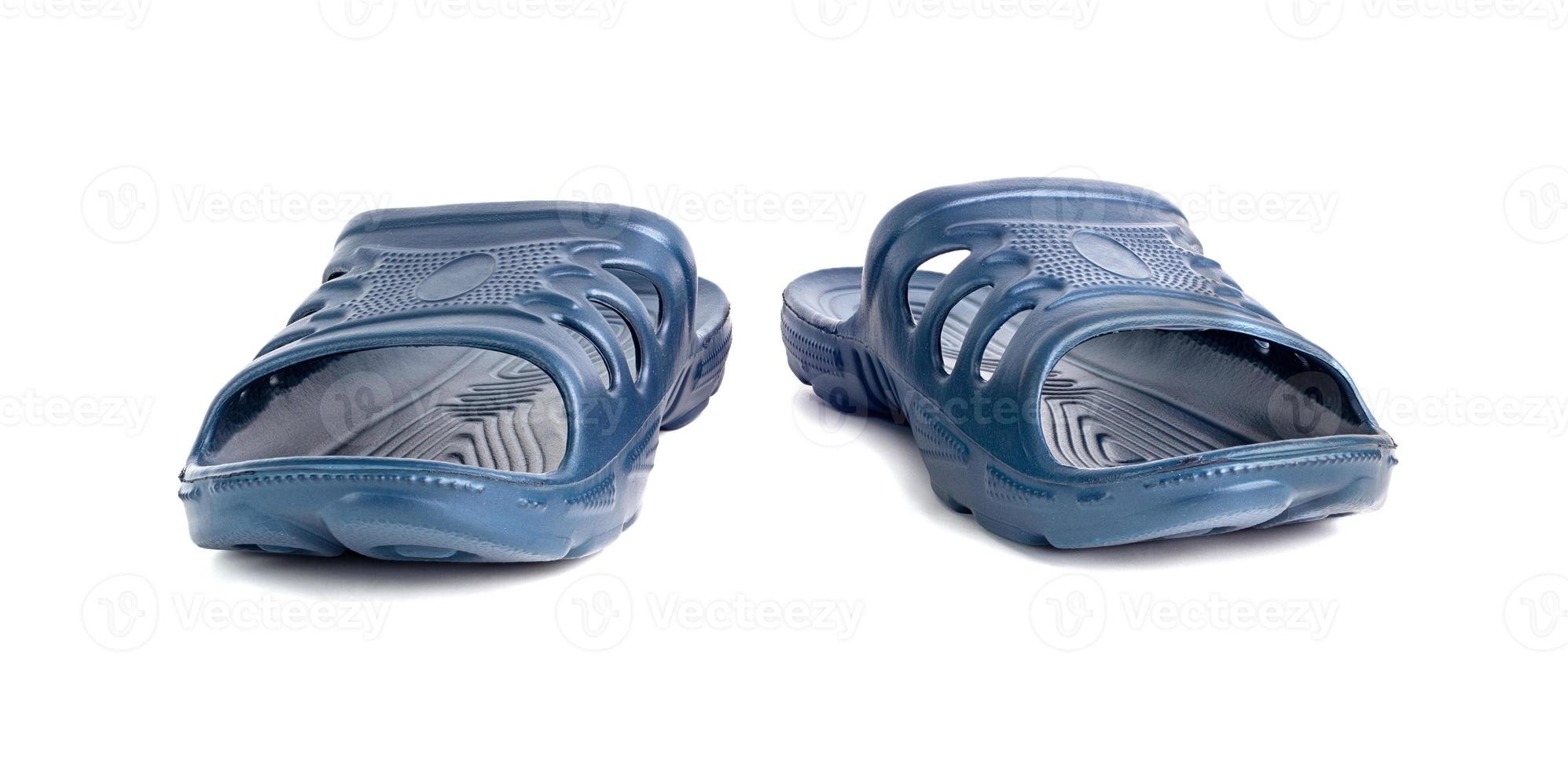 pair of cheap durable blue rubber slippers isolated on white background. photo