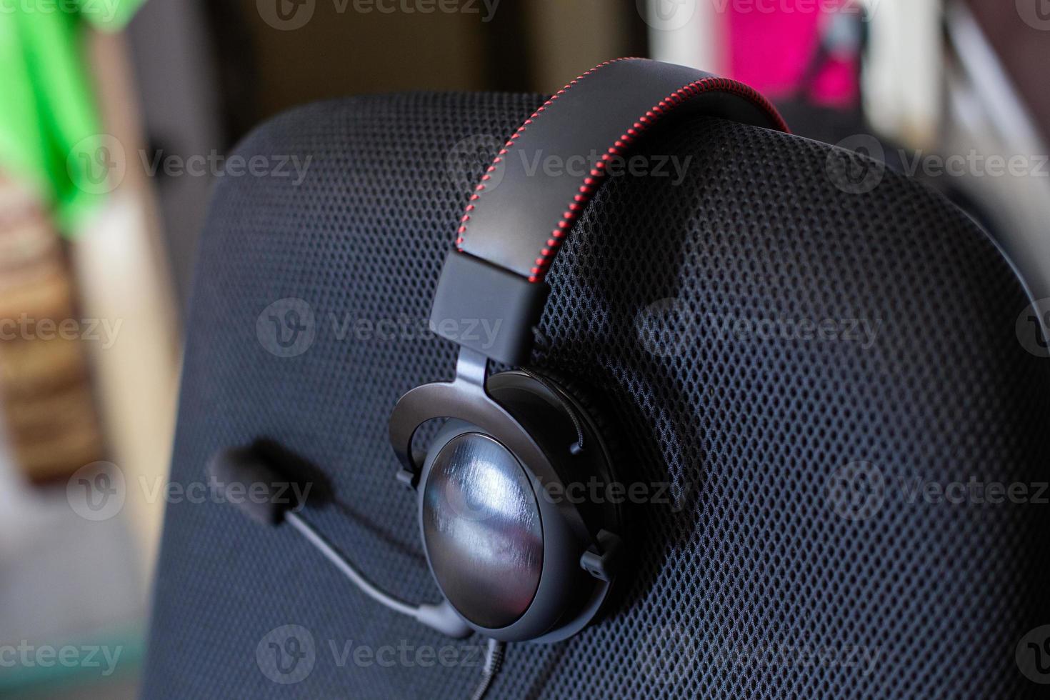 black headset on backrest of empty computer chair with air mesh upholstery photo