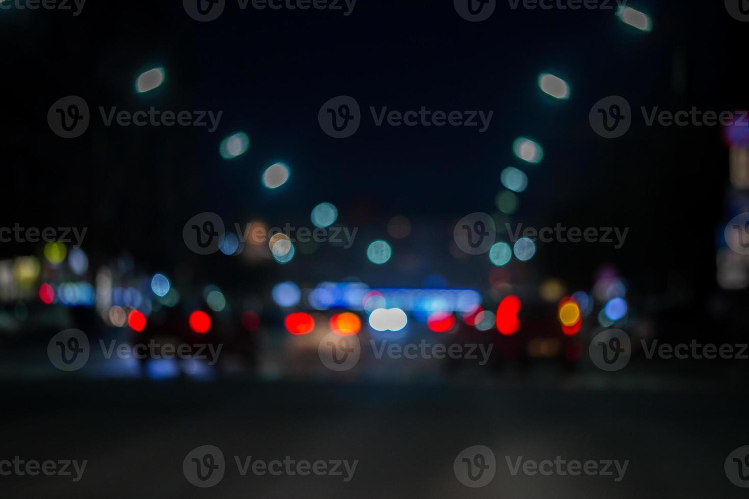 vista desenfocada desde la ventana del camión con iluminación borrosa del tráfico de la ciudad en las calles de la ciudad por la noche, fondo borroso foto