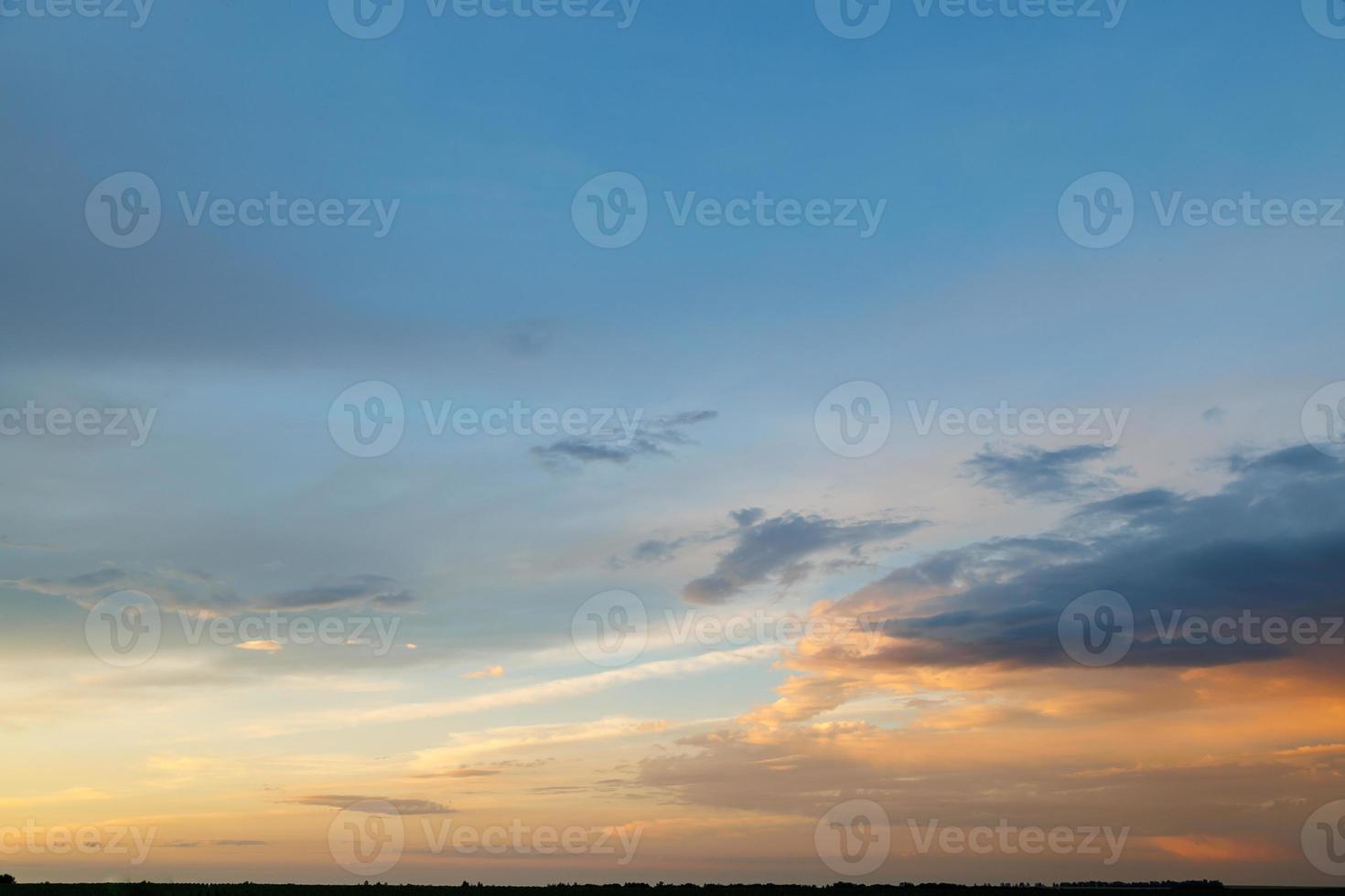 cielo de la tarde, parcialmente cubierto con nubes iluminadas de manera diferente foto