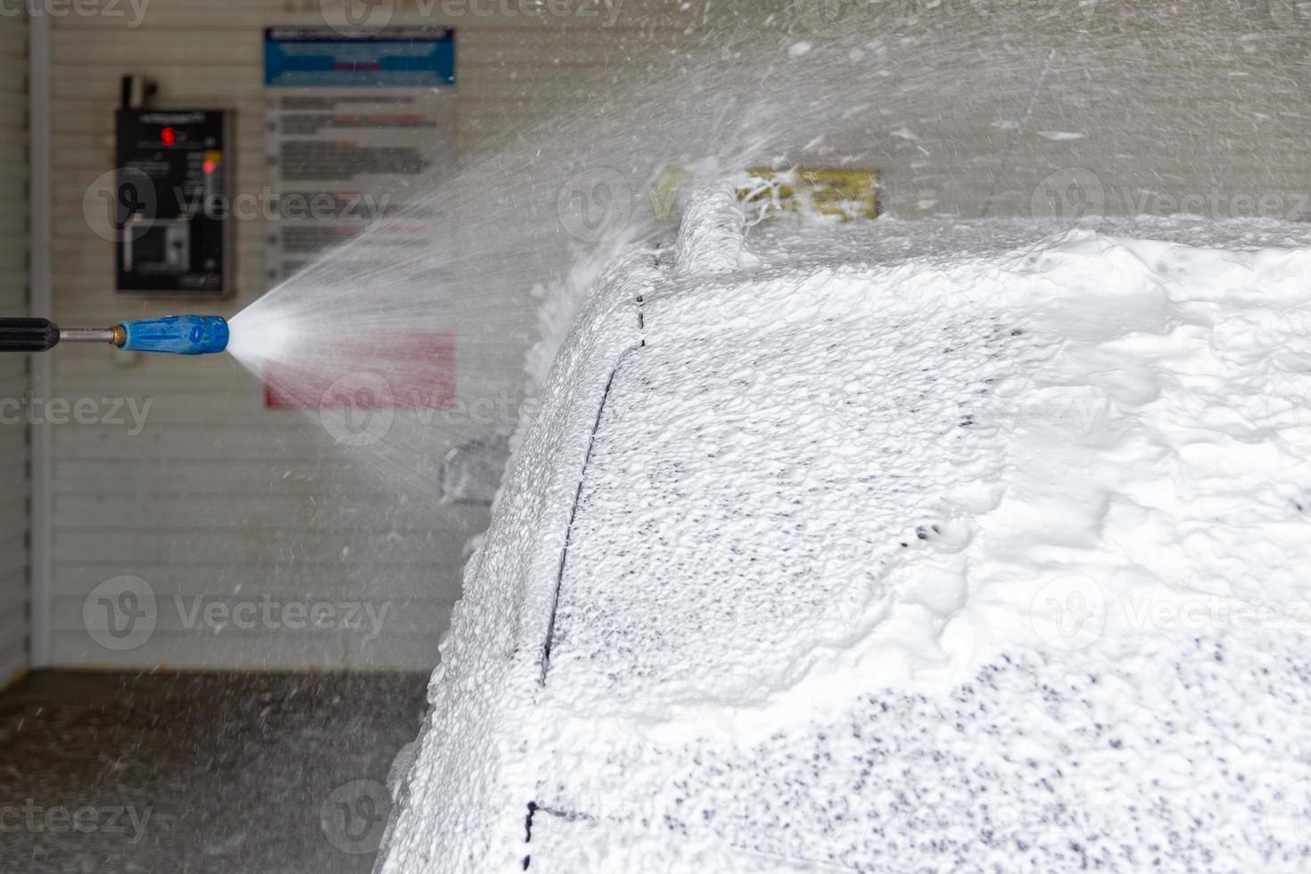 A process of applying soap sud in carwash station - closeup with selective focus photo