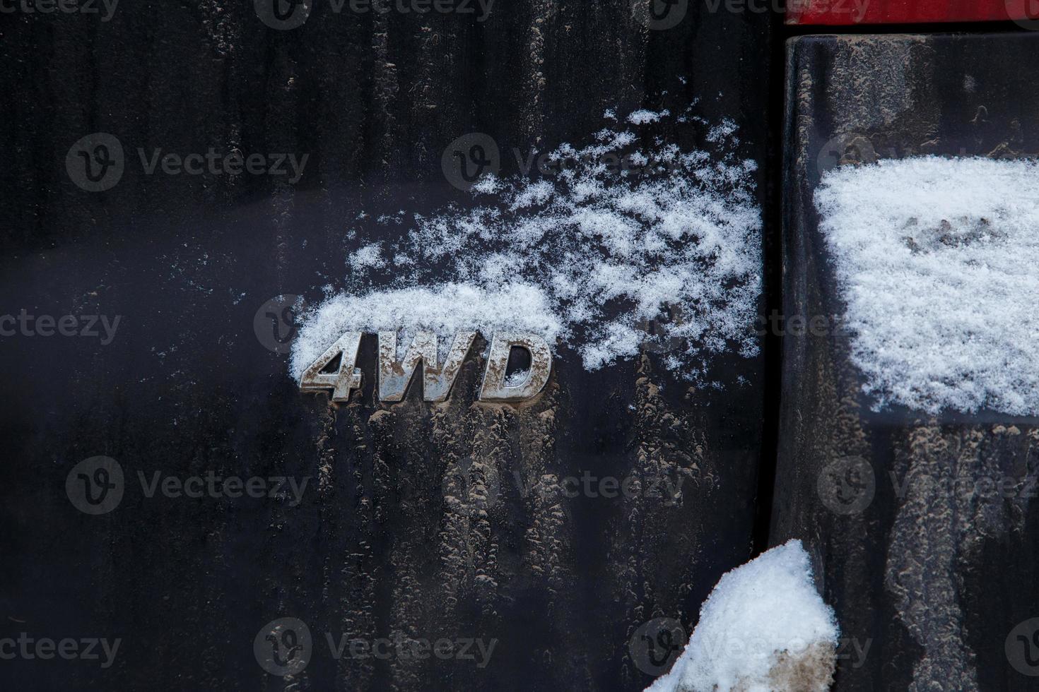 an abbreviation 4wd - Four-wheel drive - on dirty black car back photo