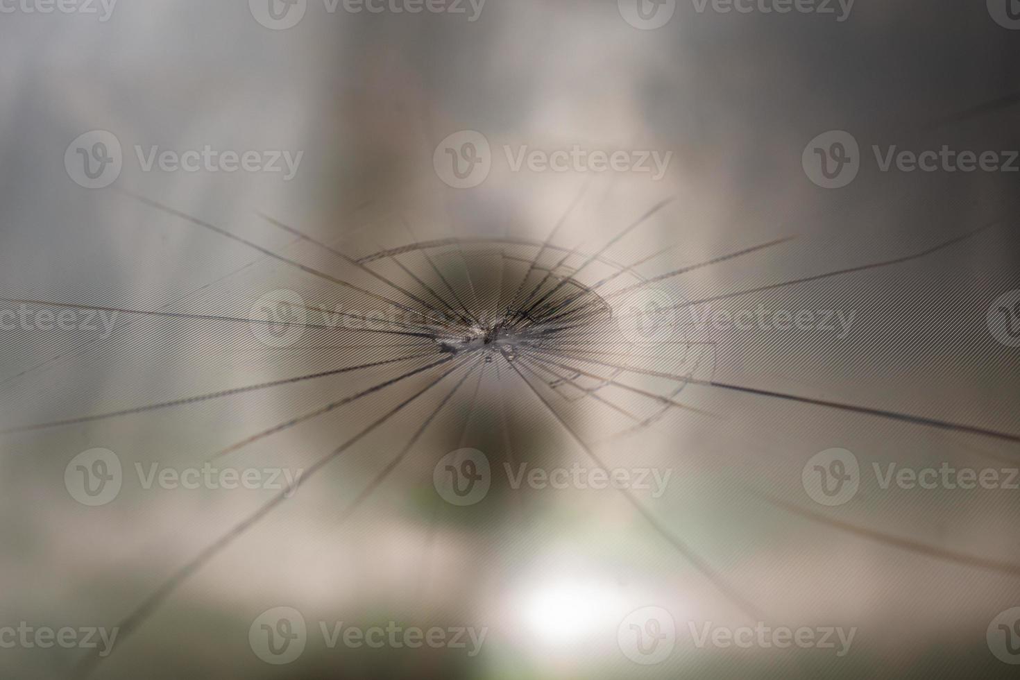 abstract background of broken tft lcd with localized radial cracks from one hit - close-up with selective focus and blur photo