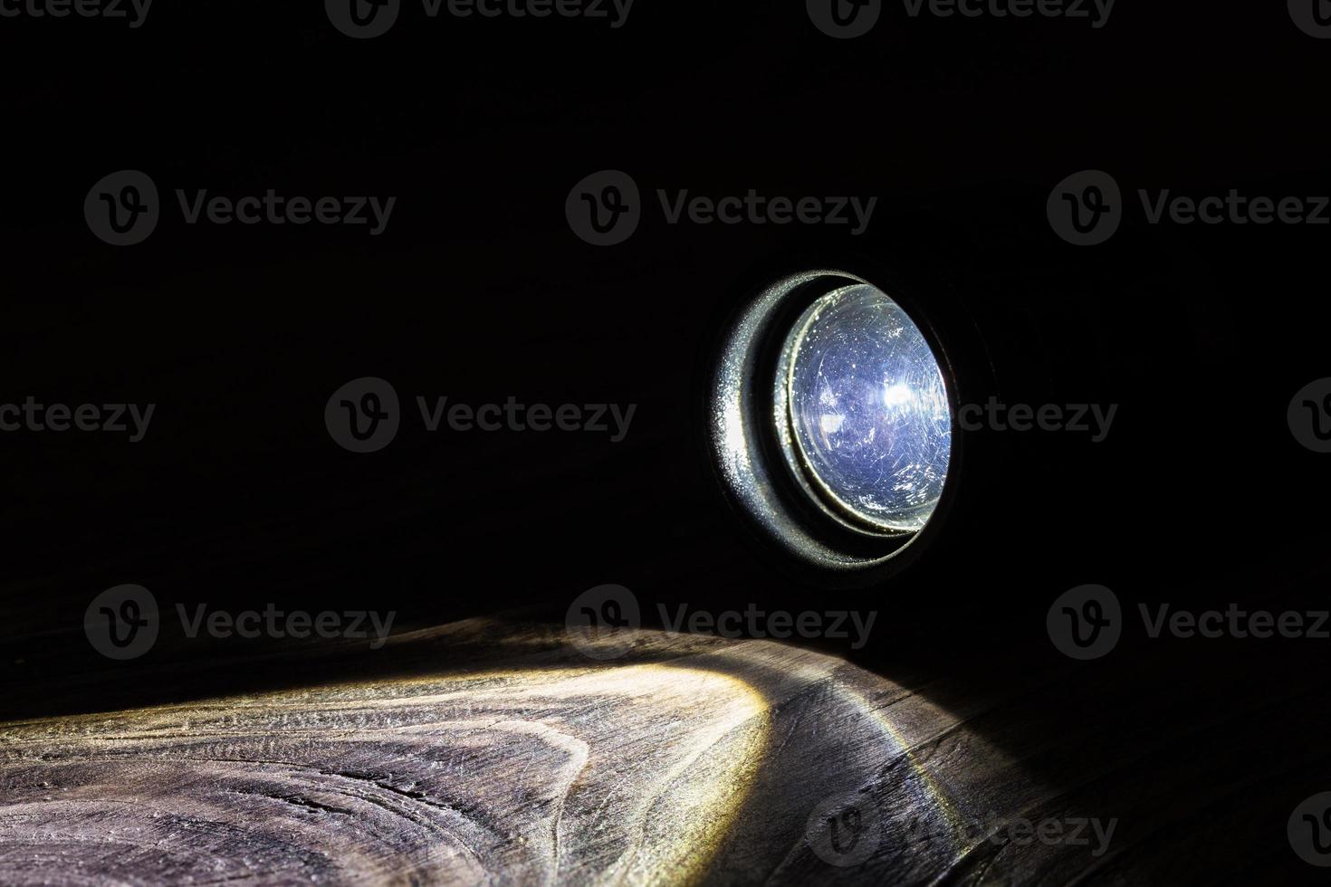 black led operational flashlight on rough wooden surface - closeup photo