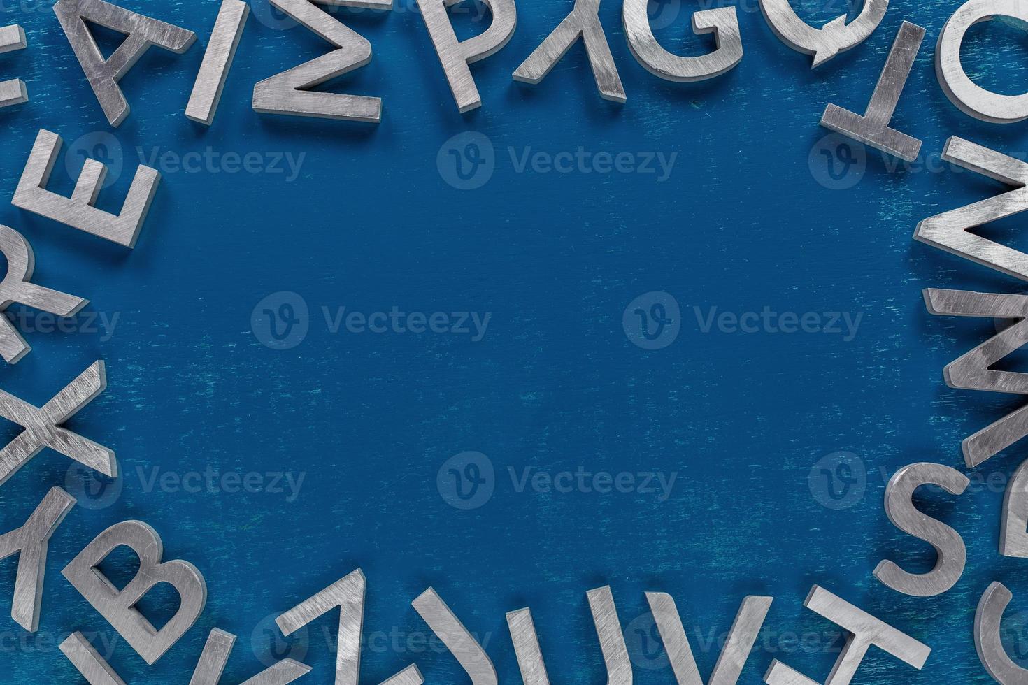 Frame mockup made of of silver metal english alphabet characters on classic blue background. photo