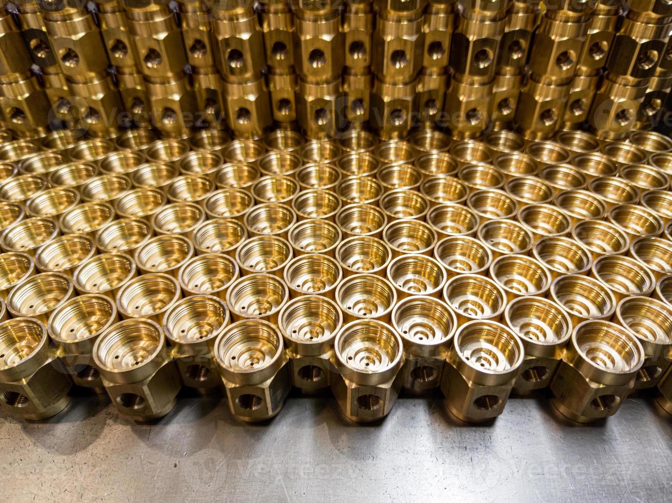 an abstract industrial close-up background of shiny brass metal threaded hexagonal fitting parts photo