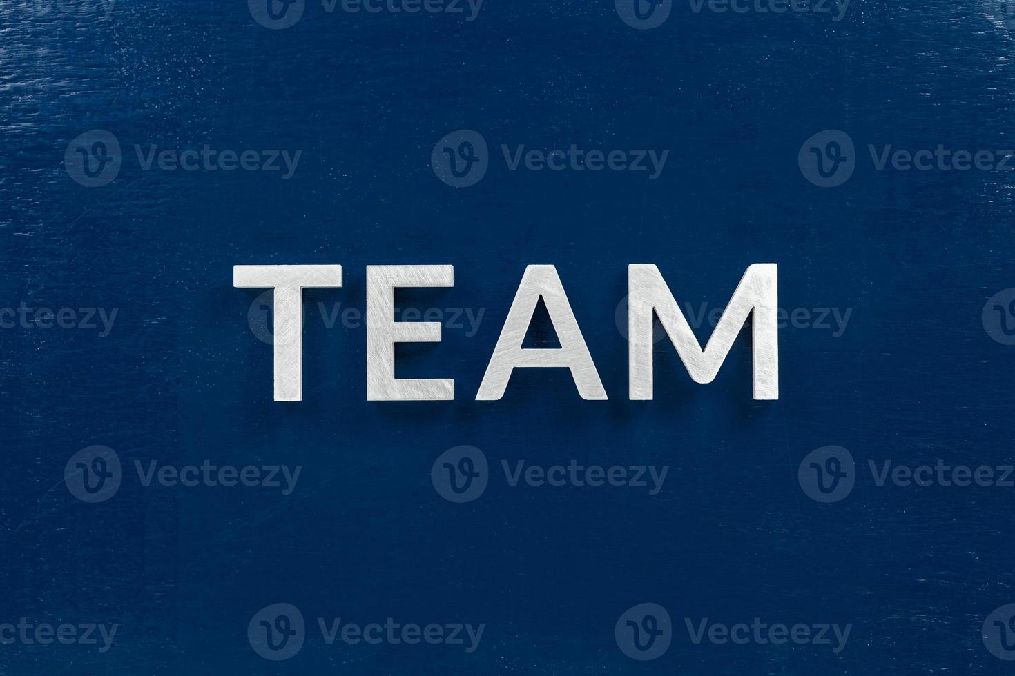 the word team laid with aluminium letters on dark-blue flat background photo