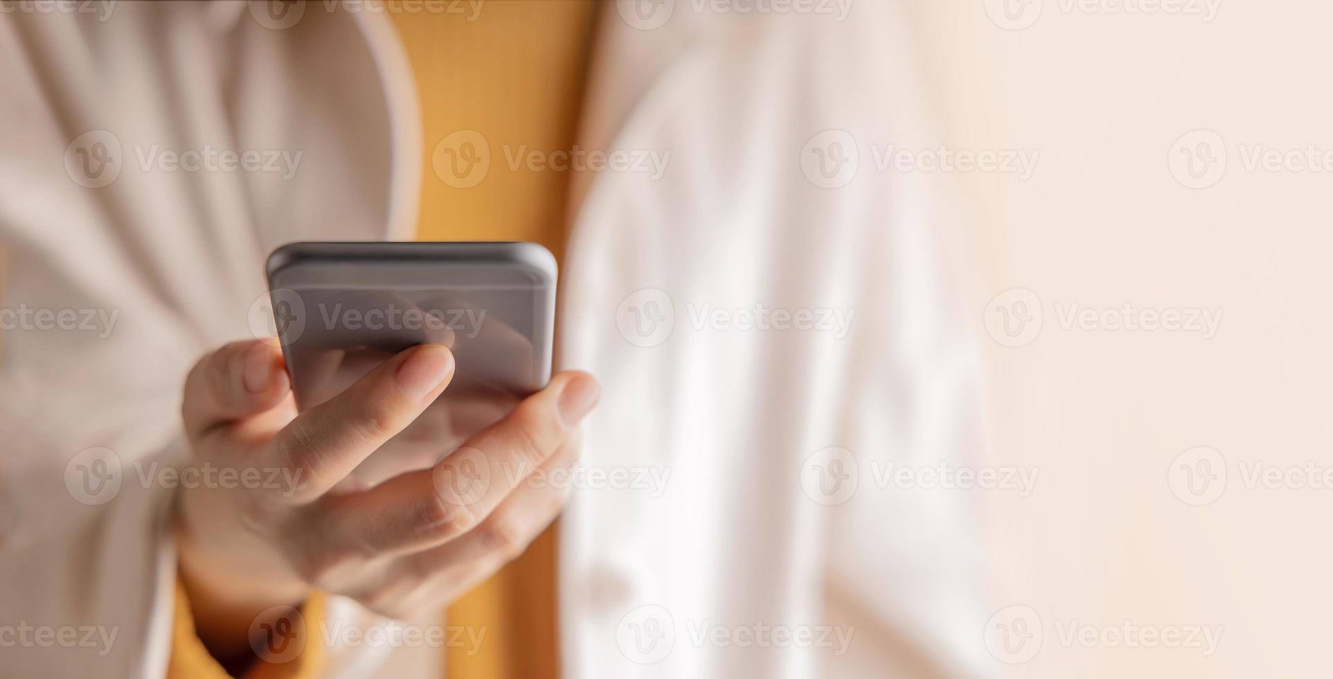 Closeup of Hand Using Mobile Phone. Cropped image. Selective Focus. Using Smartphone for Communication, Texting, Reading or Playing Game photo