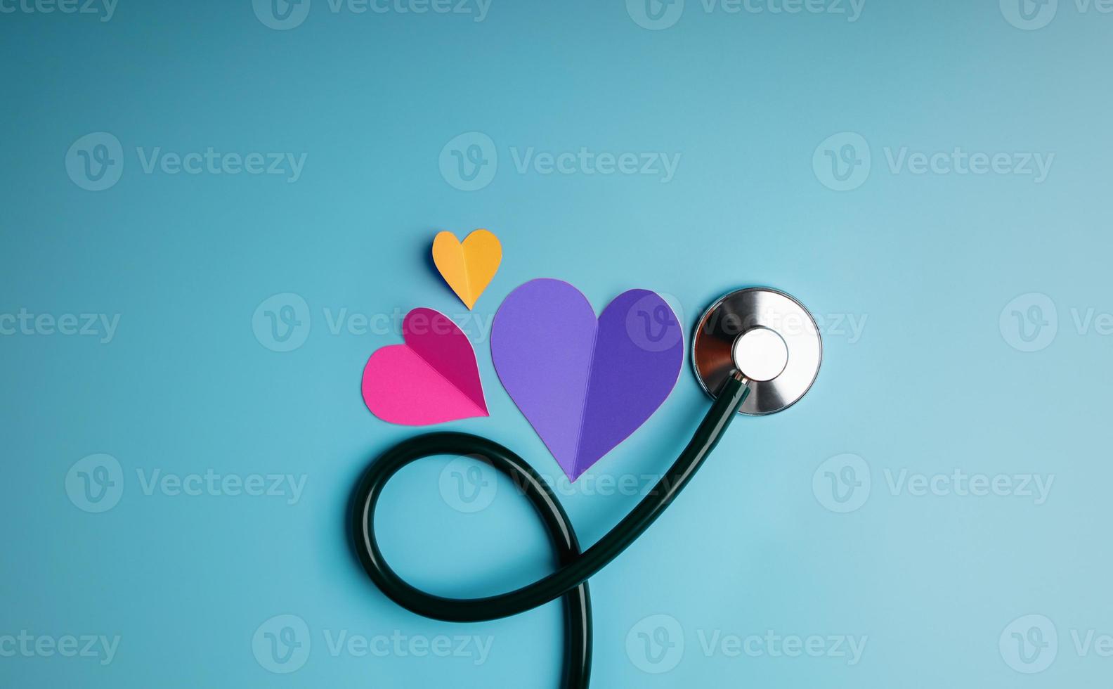 Health Care Concept. International World Heart Day. Paper Cut as Heart Shape with Stethoscope lay on Blue background. Life, Love and Care. Top View photo