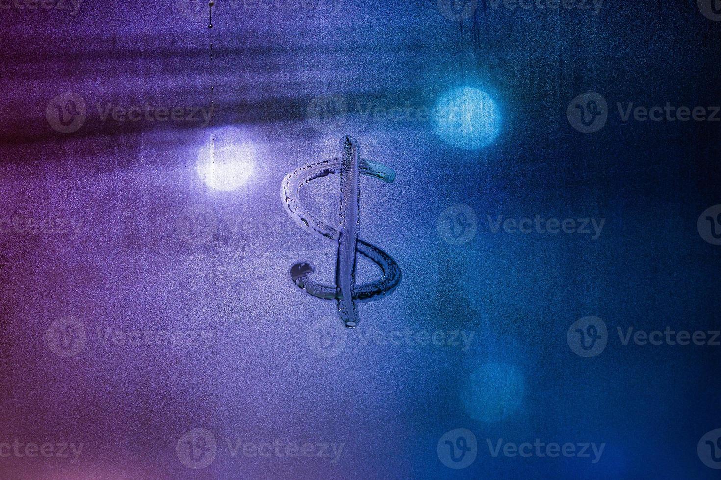 Dollar currency sign handwritten on fogged window. Dollar symbol on wet night window surface. photo