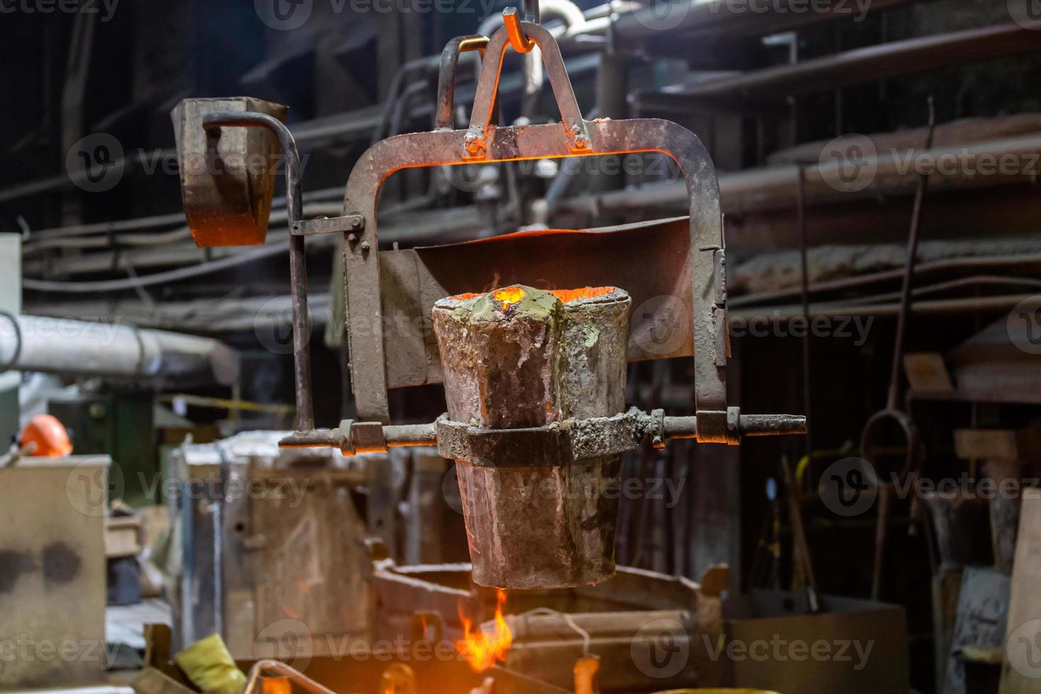 small metallurgical ladle with molten steel moves on a hook of crane photo