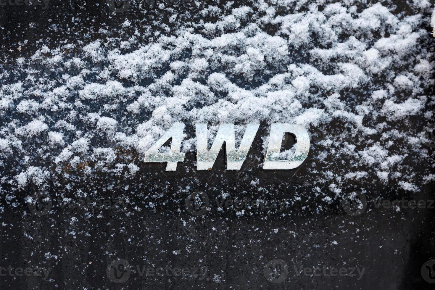 an abbreviation 4wd - Four-wheel drive - on dirty black car back photo