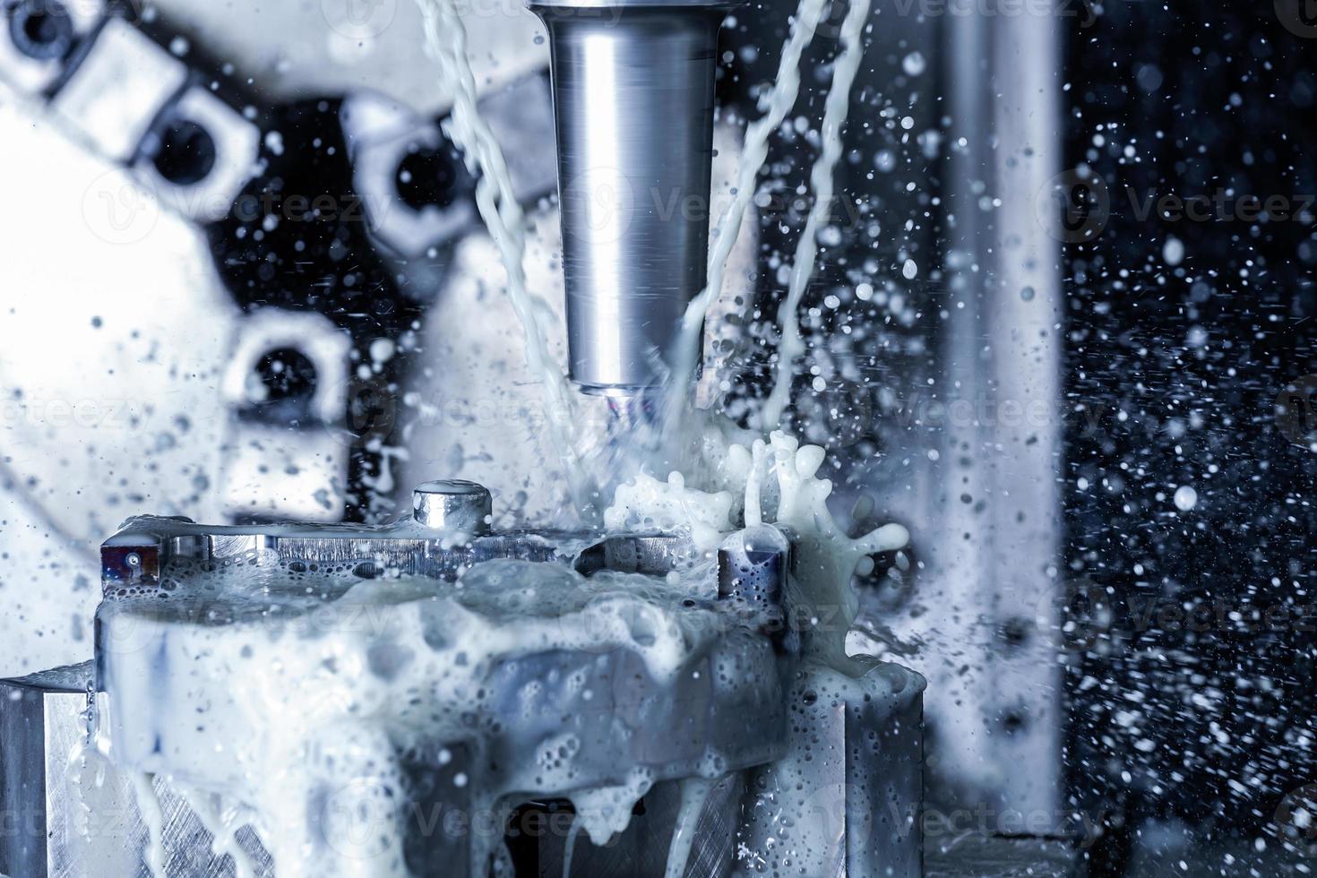 vertical cnc steel milling with external water coolant streams and splashes photo