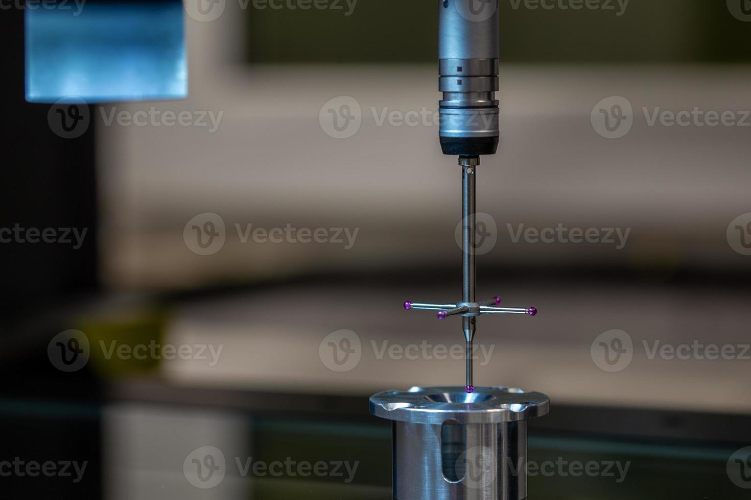 cmm - máquina de medición por coordenadas - sonda de contacto mide la pieza de aluminio en la superficie de la mesa de vidrio. Control de producción de fabricación de alta precisión. foto