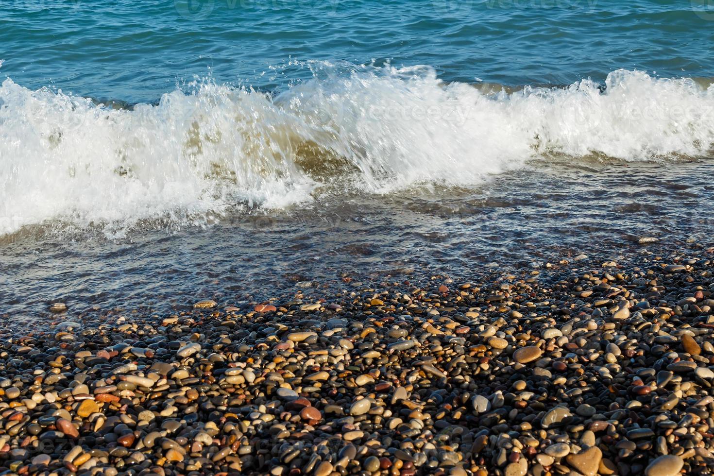 Sea shore with round stones on the mediterranean coast. Horizontal image. photo