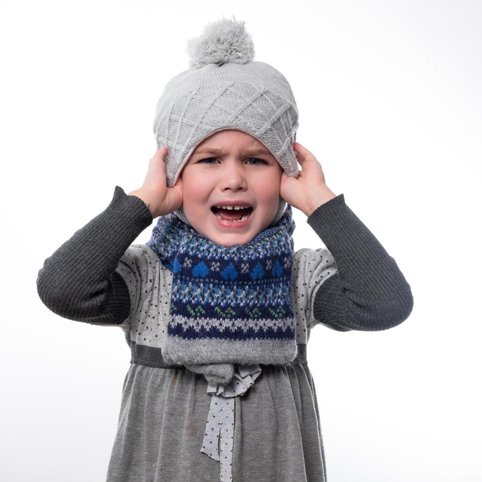 Portrait of a little girl in a hat and scarf on a white background. photo