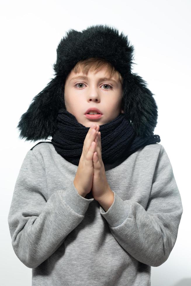 retrato de un niño de fondo blanco con un sombrero con orejas y una bufanda. foto